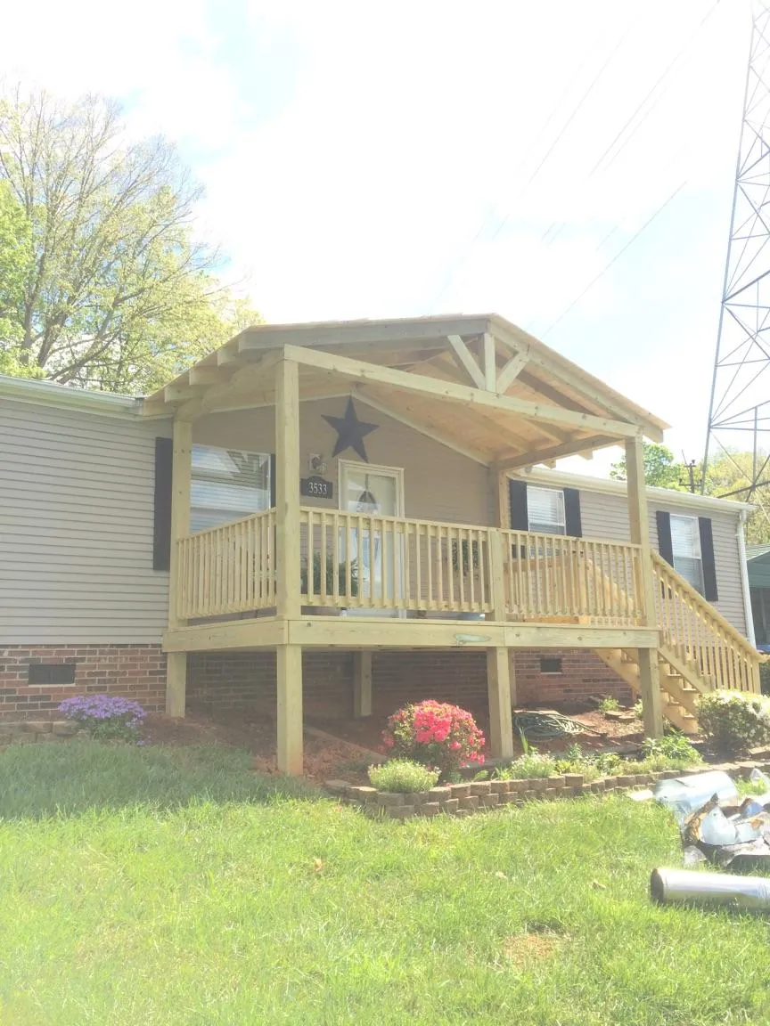 New gabled porch roof and deck railing added to a ranch home in Grundy Center